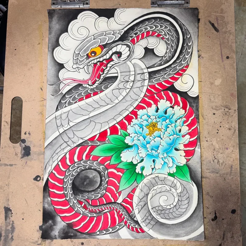 Vibrant Japanese painting of coiled hebi snake with red and white striped belly and yellow eye, entwined with large blue botan peony and green leaves. Traditional kumo cloud background. Watercolor and ink.
