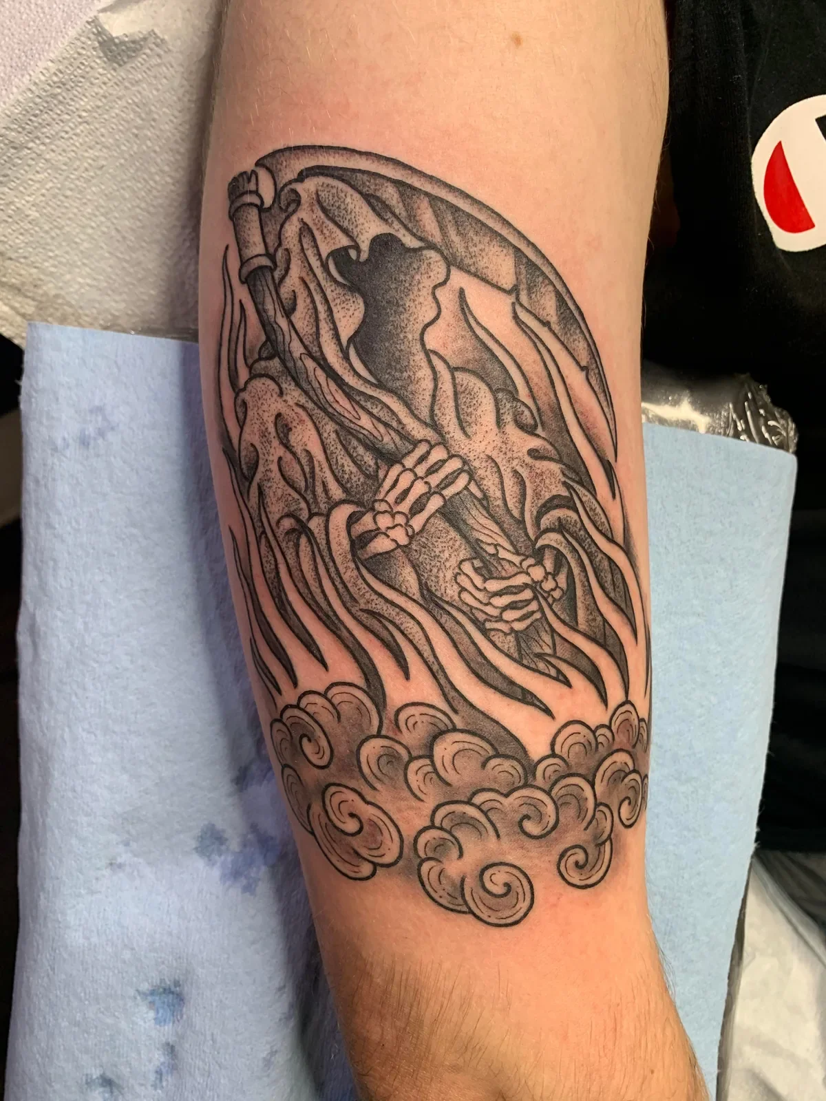 Faceless reaper wrapped in flowing robes and Japanese-style clouds — stipple shading, bold trad bones.
