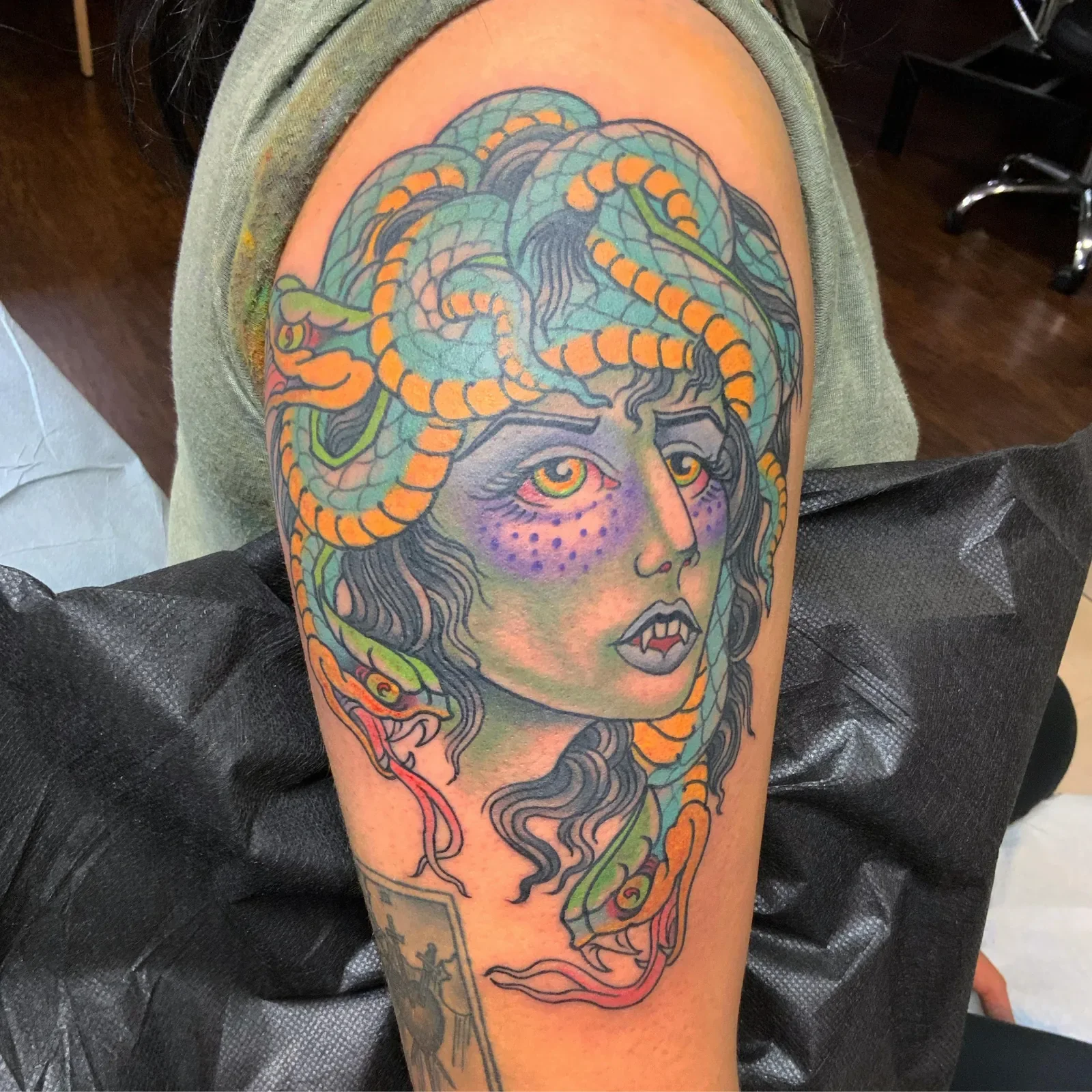  Medusa in vibrant trad color — mint and orange serpents, purple dotwork and fanged portrait.
