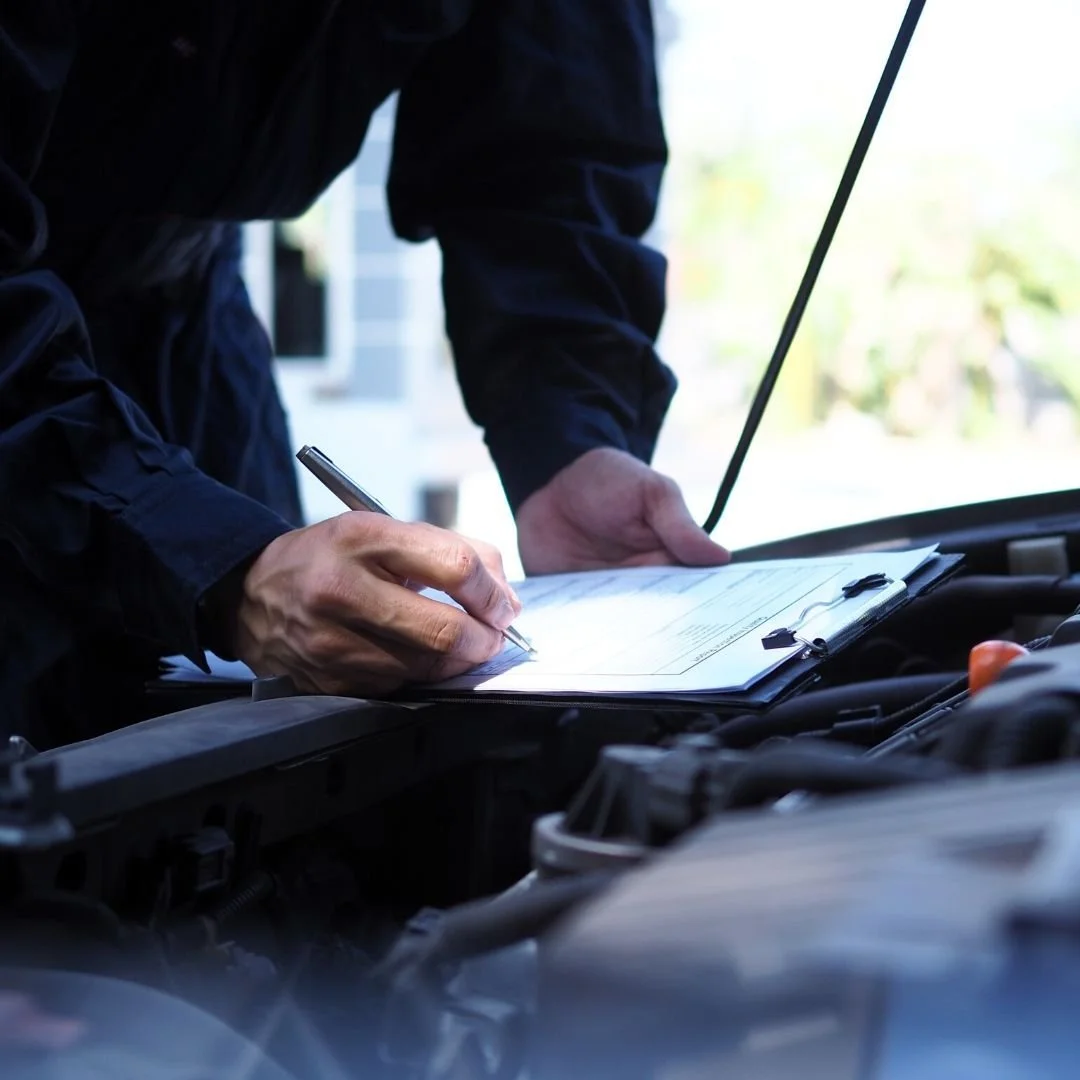 Automotive technician performing a comprehensive multi-point vehicle inspection.