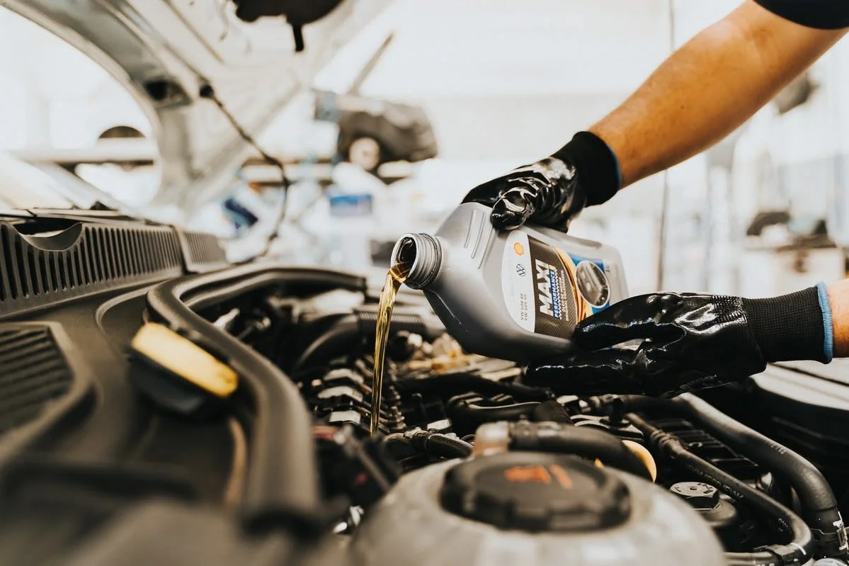Pouring fresh engine oil into a vehicle during a routine oil change service.