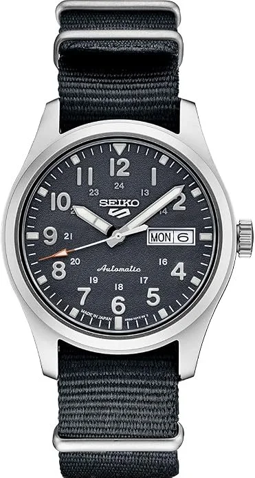 Seiko 5 automatic wristwatch with black dial, silver case, and black nylon strap showing time, date, and day.