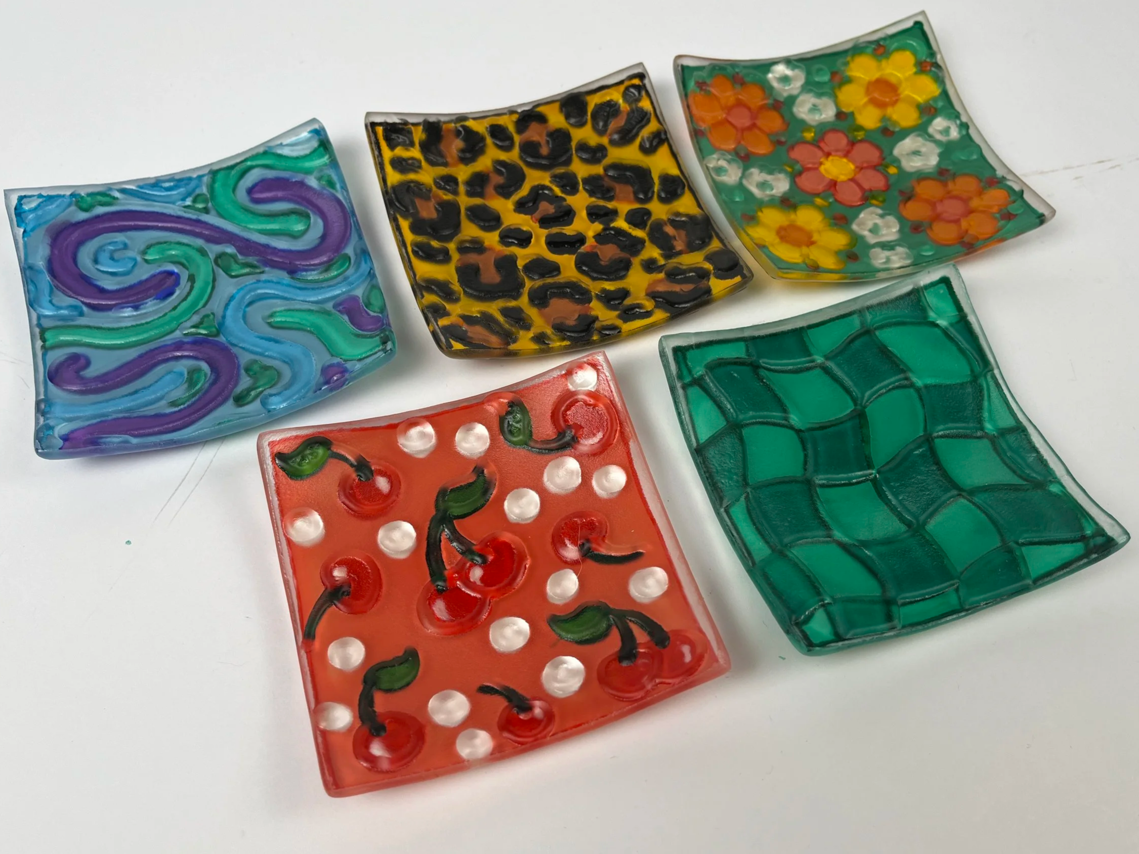 Small textured glass trinket trays and bowls hand painted with fun and quirky designs like checkers, swirls, flowers, and fruit