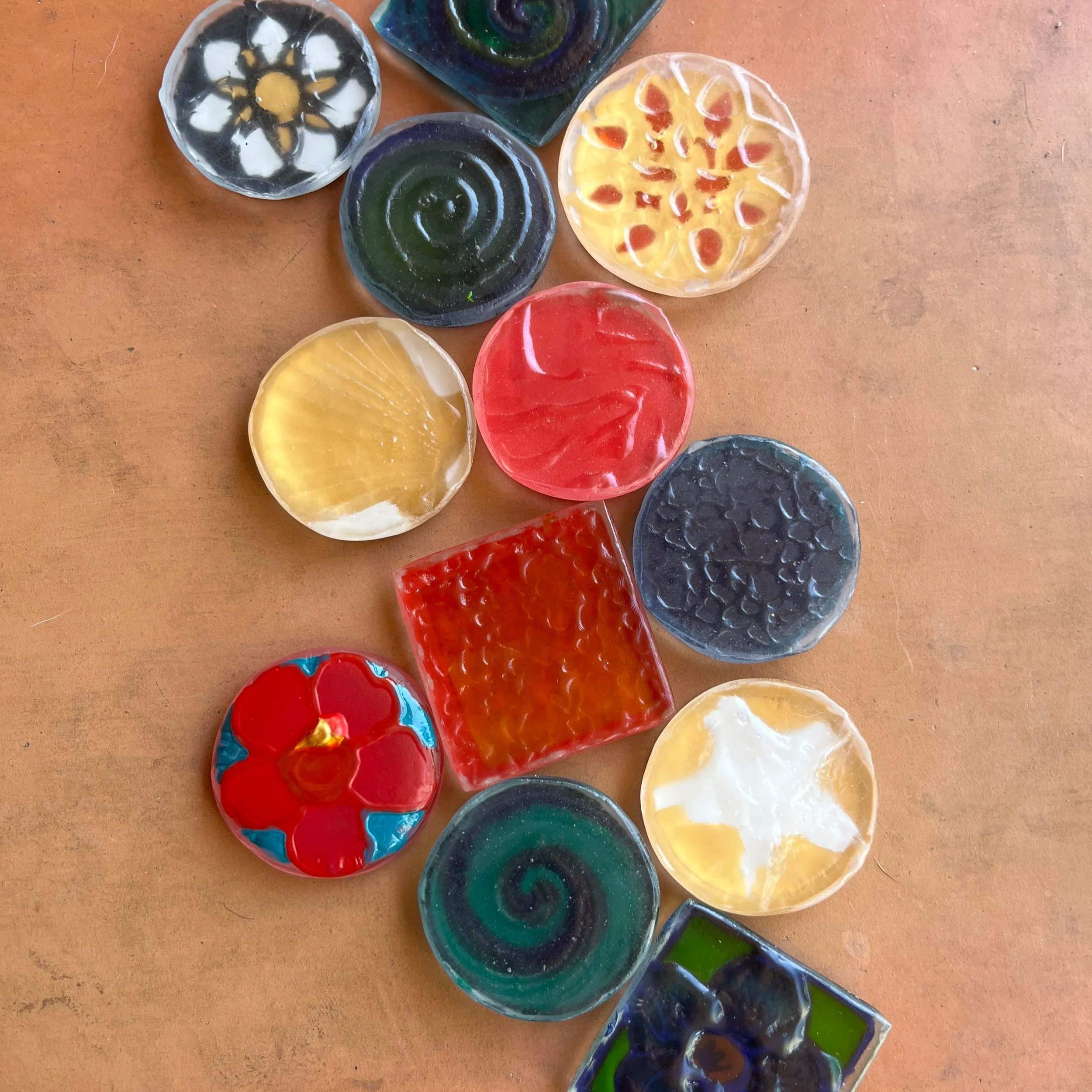 A variety of multiple colorful glass tokens in different sizes, shapes, and colors