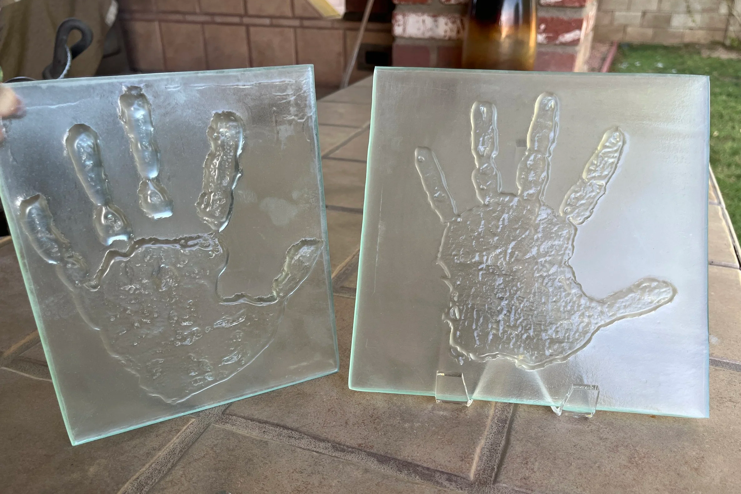 Two large textured glass pieces with handprints embedded into the surface