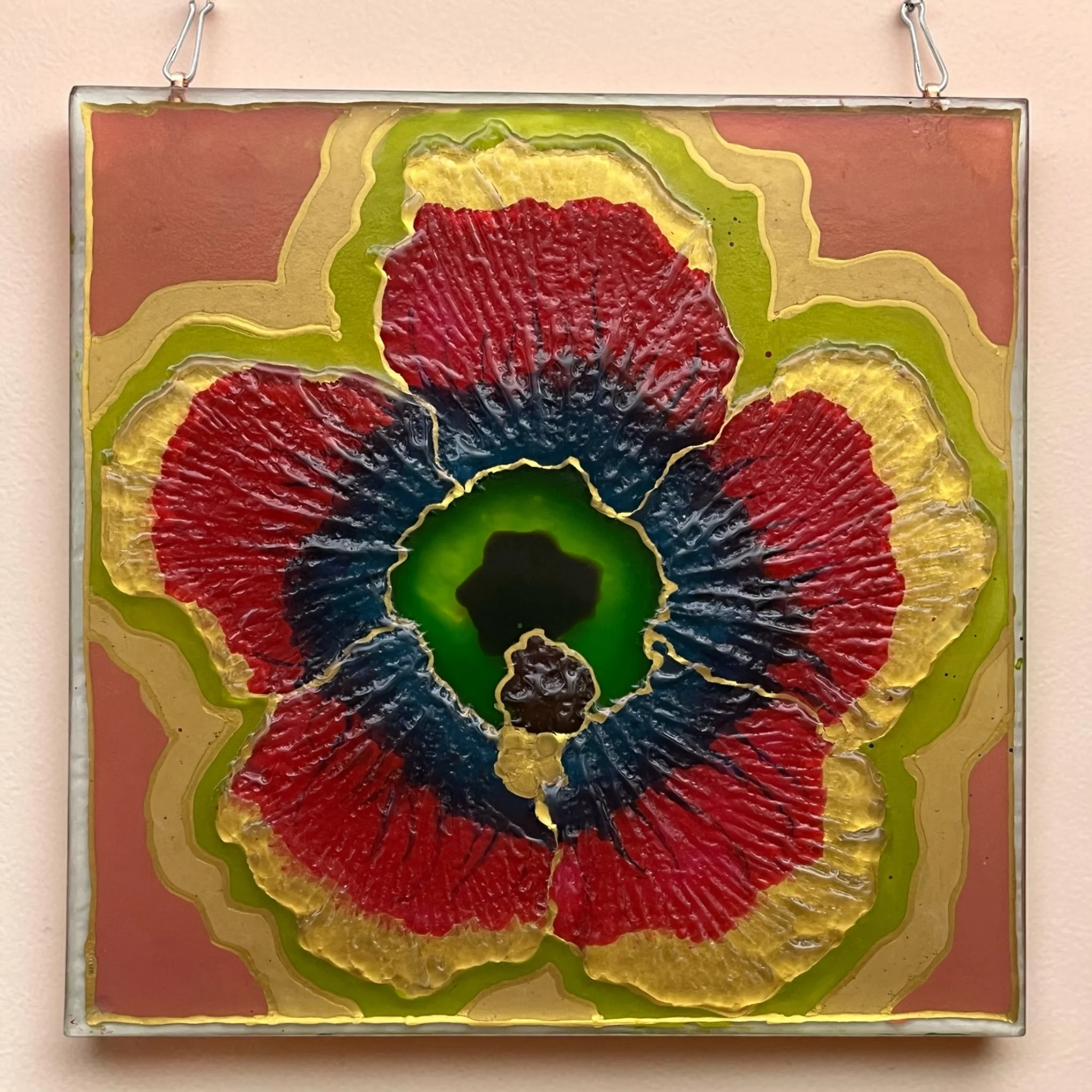 Detailed textured glass wall art featuring a hibiscus flower painted with colorful bold glass paints