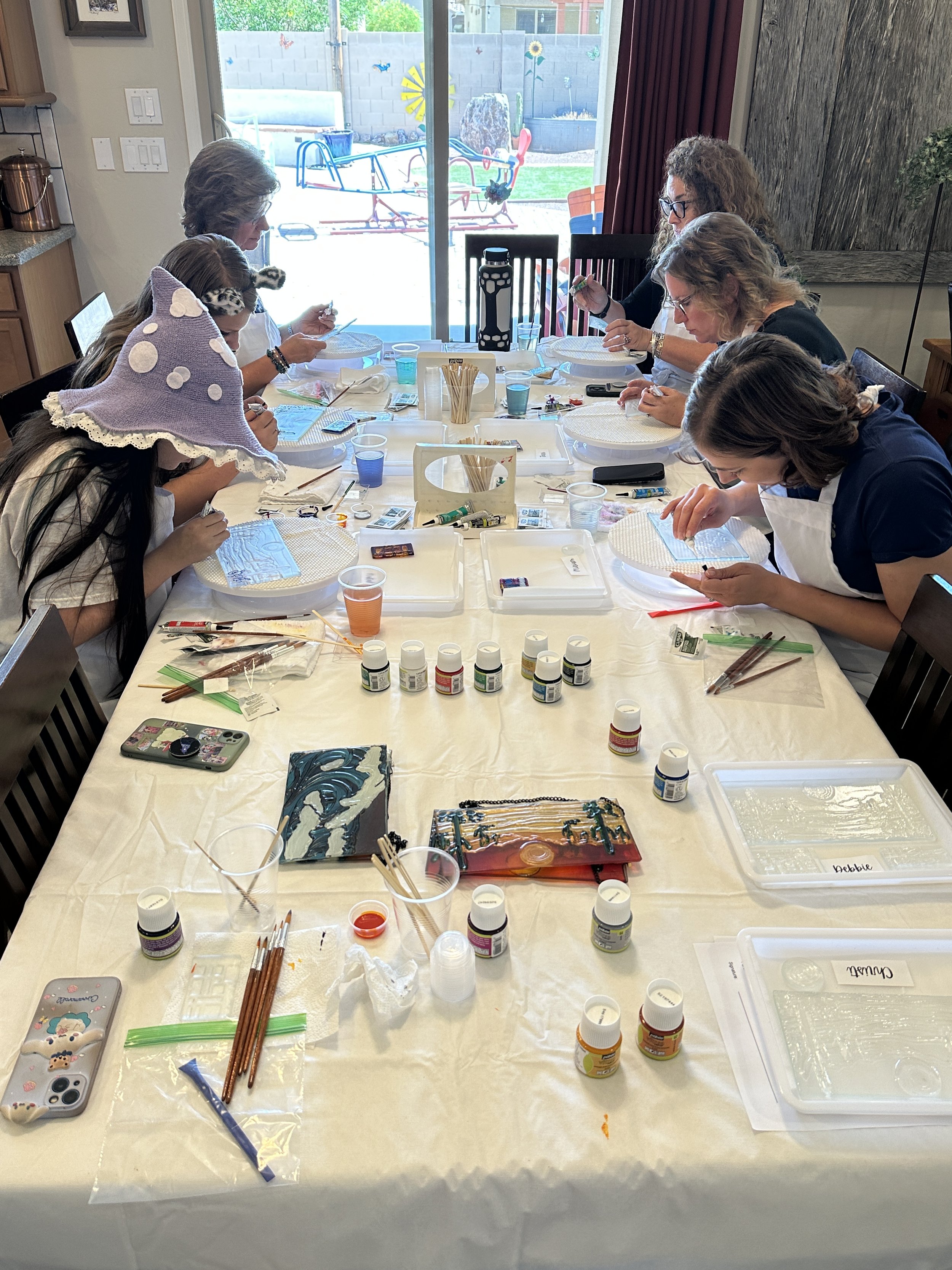 Guests at a glass painting party enjoying themselves as they paint glass art projects