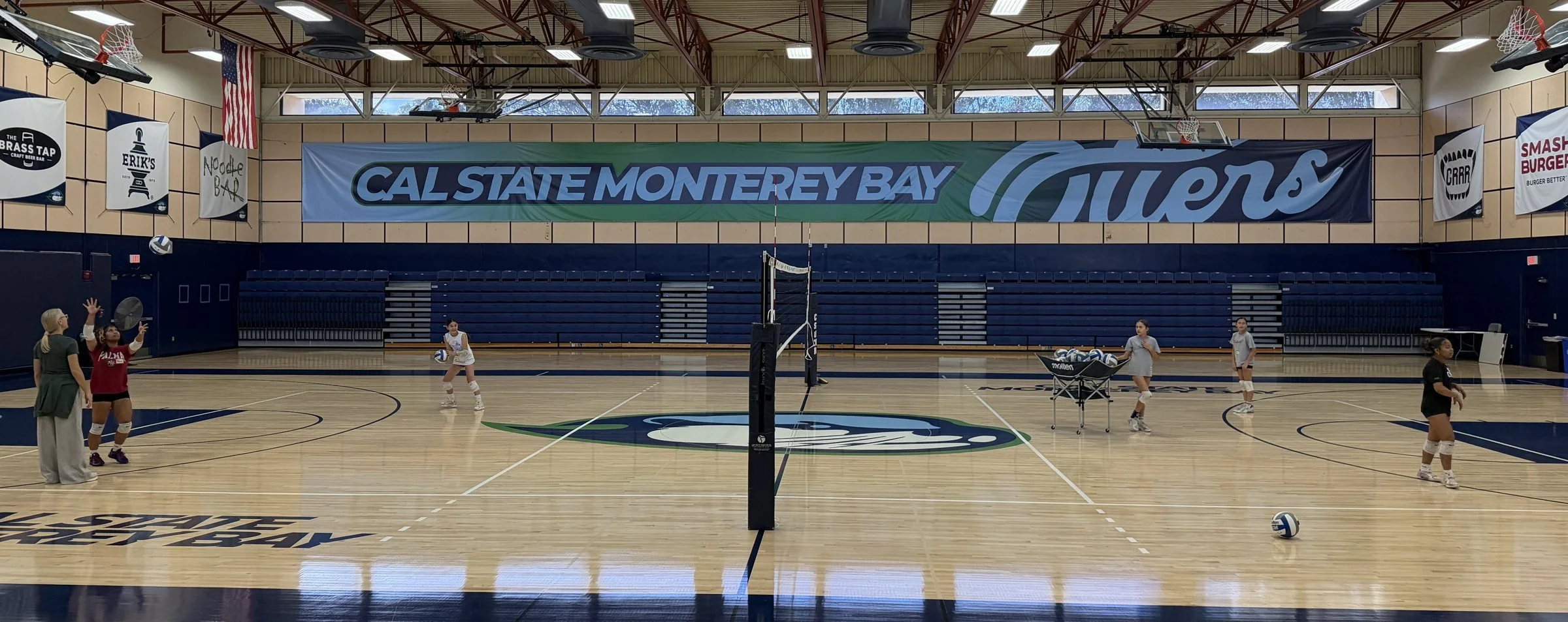 Cove athletes and a coach at a semi-private group workout in the Otter Sports Center gym at CSU Monterey Bay