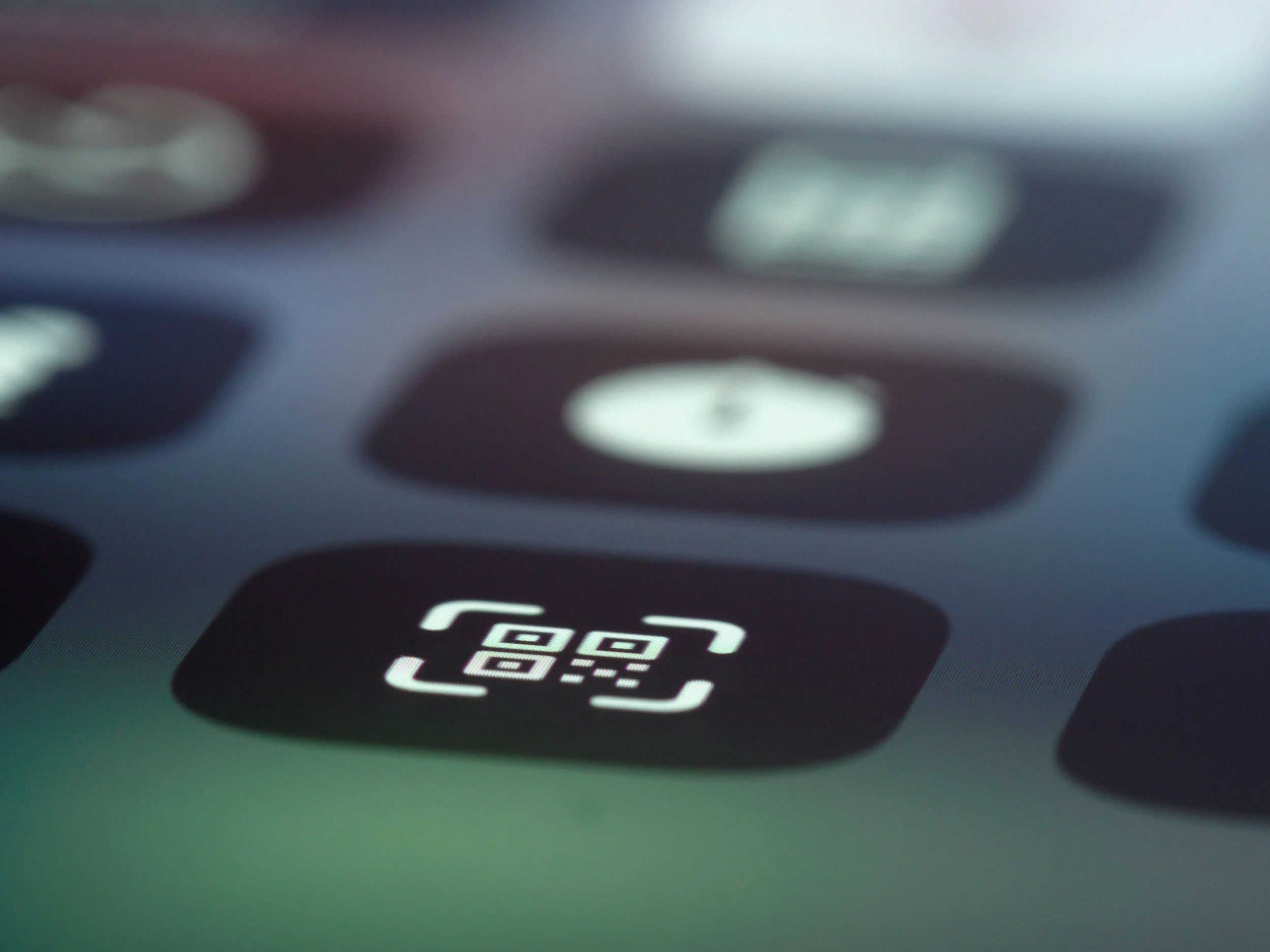 Close-up of a smartphone screen showing a QR code and a scanning icon.