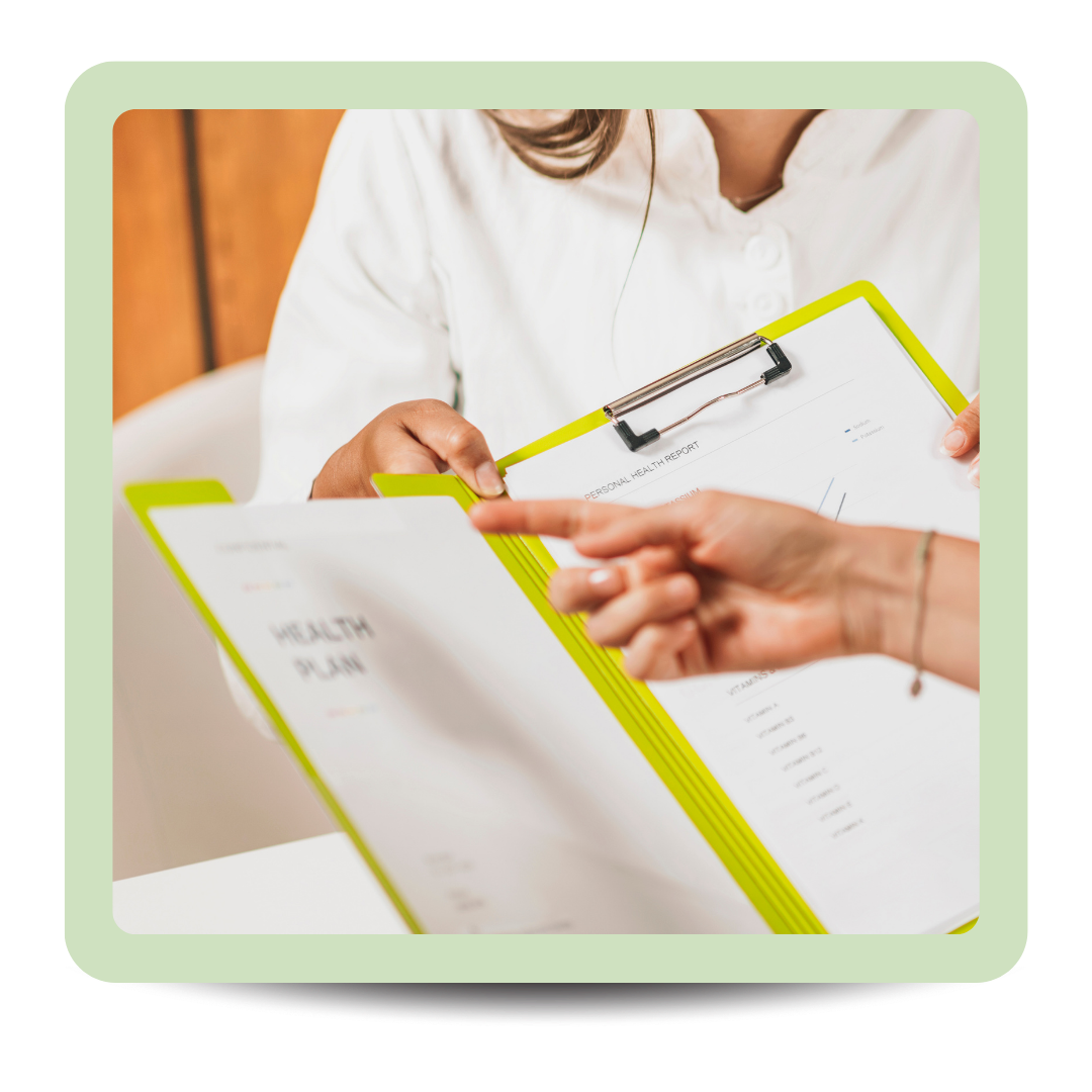 Two people discussing a health plan, one holding a clipboard with a health report and the other pointing at it.