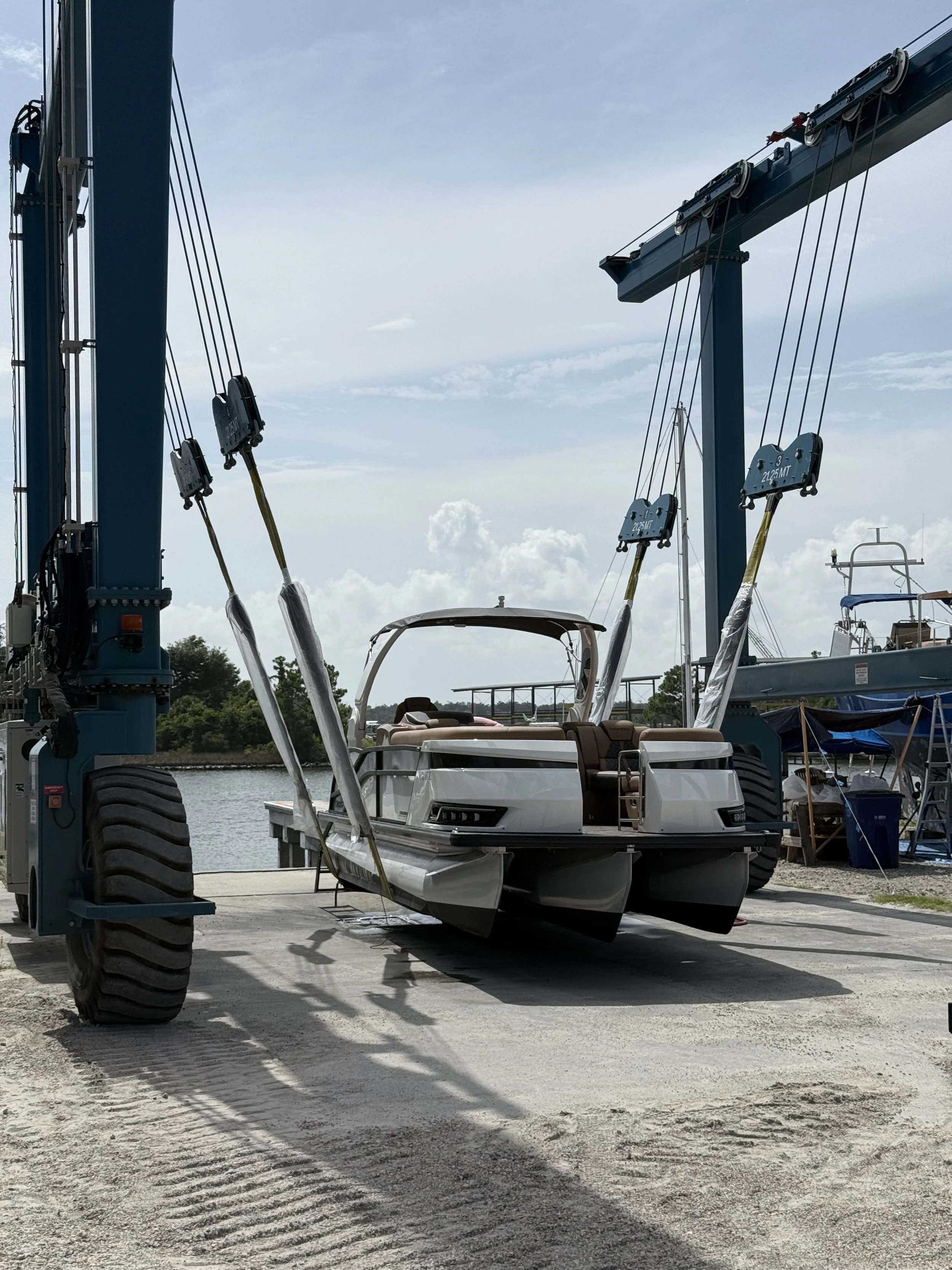 A boat strapped into a marine lift about to be placed in the water to get ready for launch