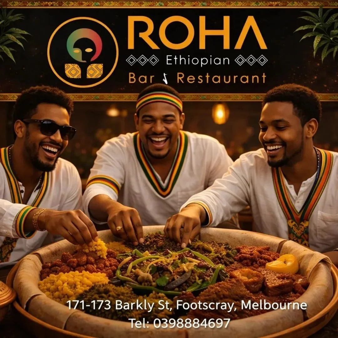 Three men with dark skin are smiling and sharing Ethiopian food at a restaurant, with a sign behind them that reads 'ROHA Ethiopian Bar & Restaurant' and includes the address and phone number.