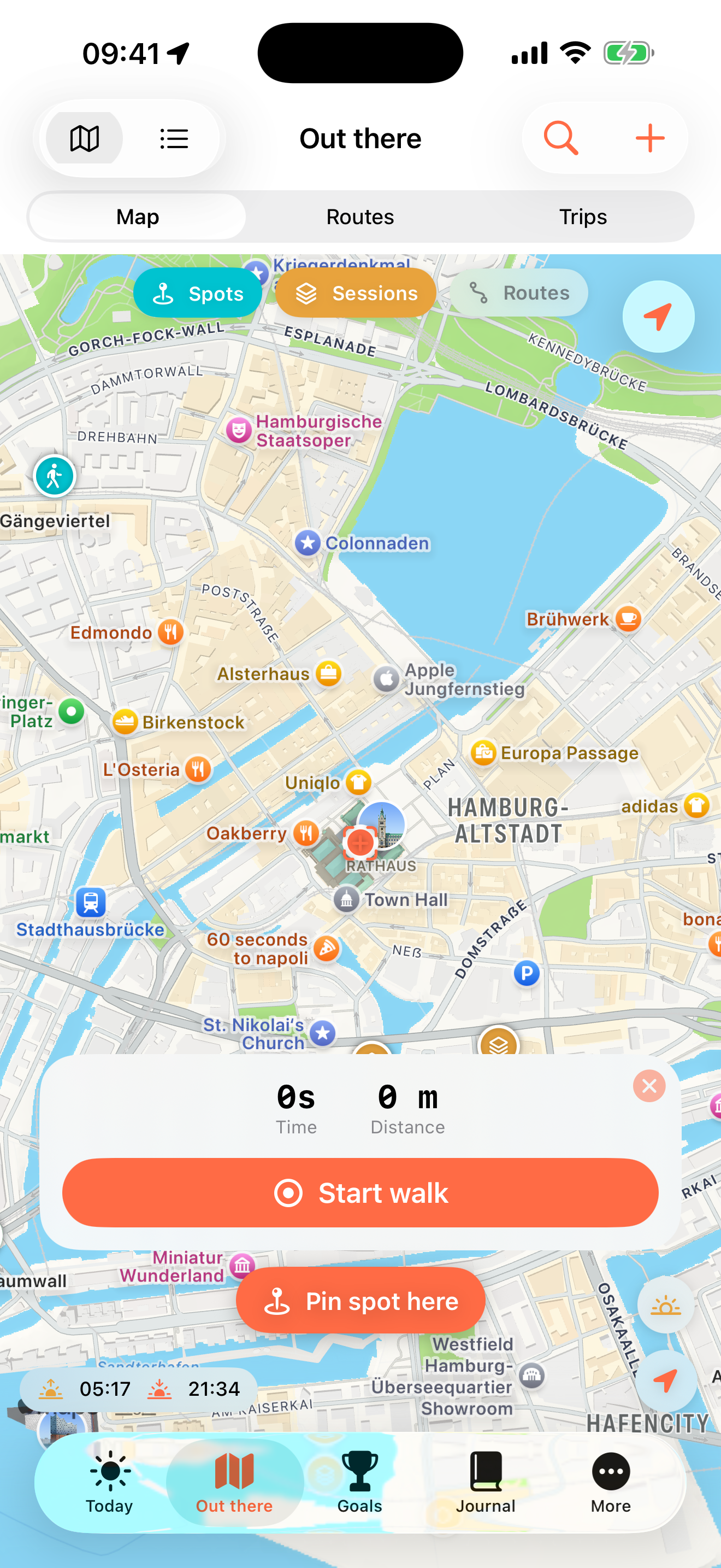 Smartphone-Display mit Kartenansicht von Hamburg, Deutschland. Enthält Symbole für Orte und Aktivitäten, Menüoptionen, Start-Button für Spaziergänge und Pin-Button, um einen Ort zu markieren. Oberer Bereich zeigt Signalstärke, Akku und Uhrzeit.
