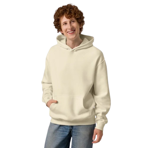 Young person with curly hair smiling, wearing a cream hoodie and jeans.