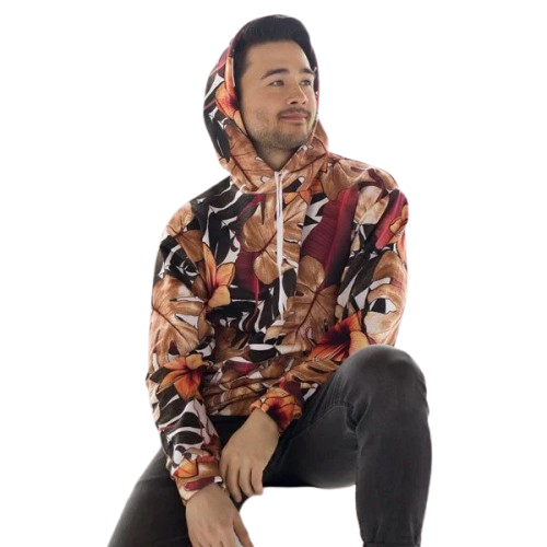 A young man wearing a floral patterned hoodie sitting with one leg up and his hands resting on his knee, against a transparent background.