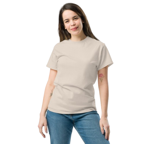 Young woman with brown hair and tattoos on arms, wearing a beige T-shirt and blue jeans, standing against a black background.