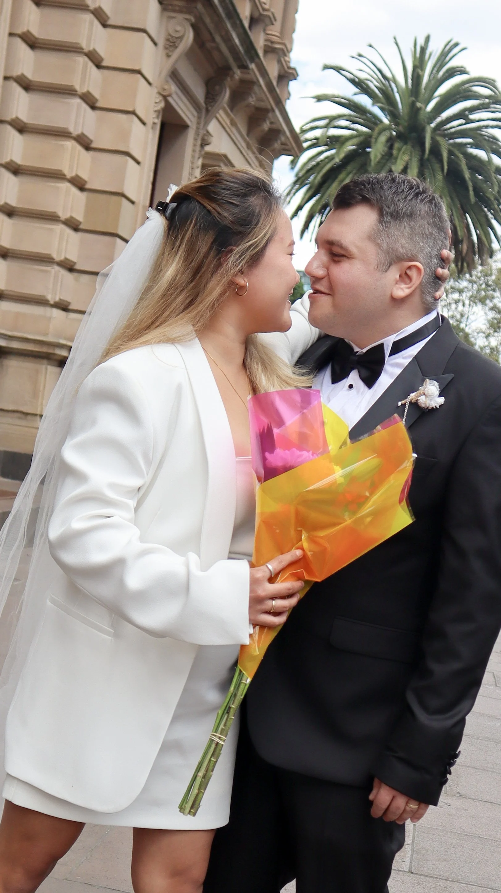 Anne's customers, Matt and Ester embracing by the Old Treasury Building