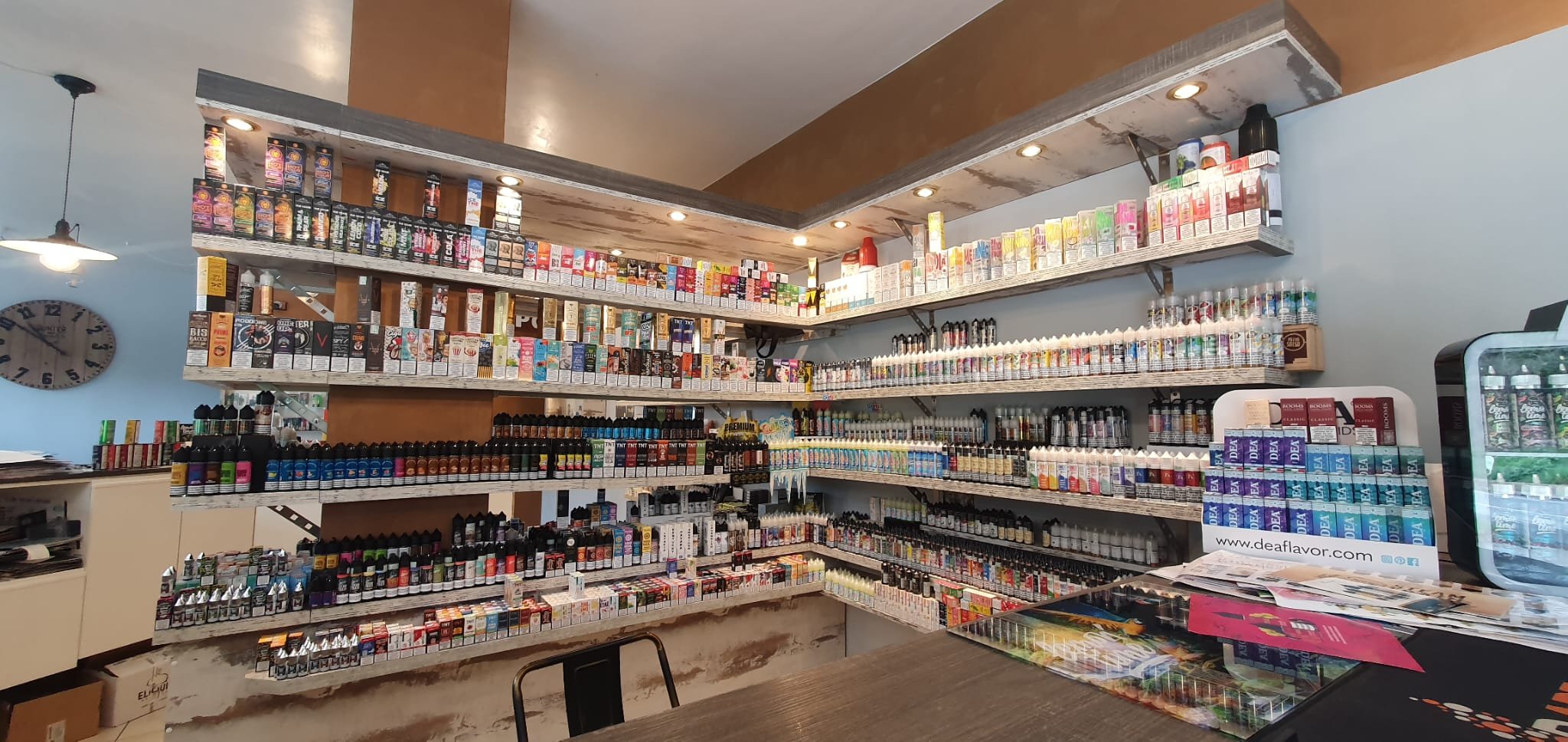 Scaffali pieni di prodotti di aromi, aromatizzanti e liquidi aromatizzati in una farmacia.