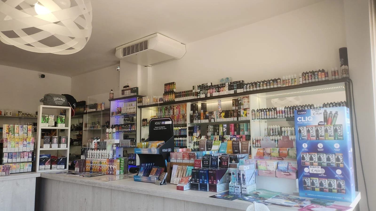 Interno di un negozio di prodotti da svapo con scaffali pieni di sigarette elettroniche e liquidi per vaporizzatori.