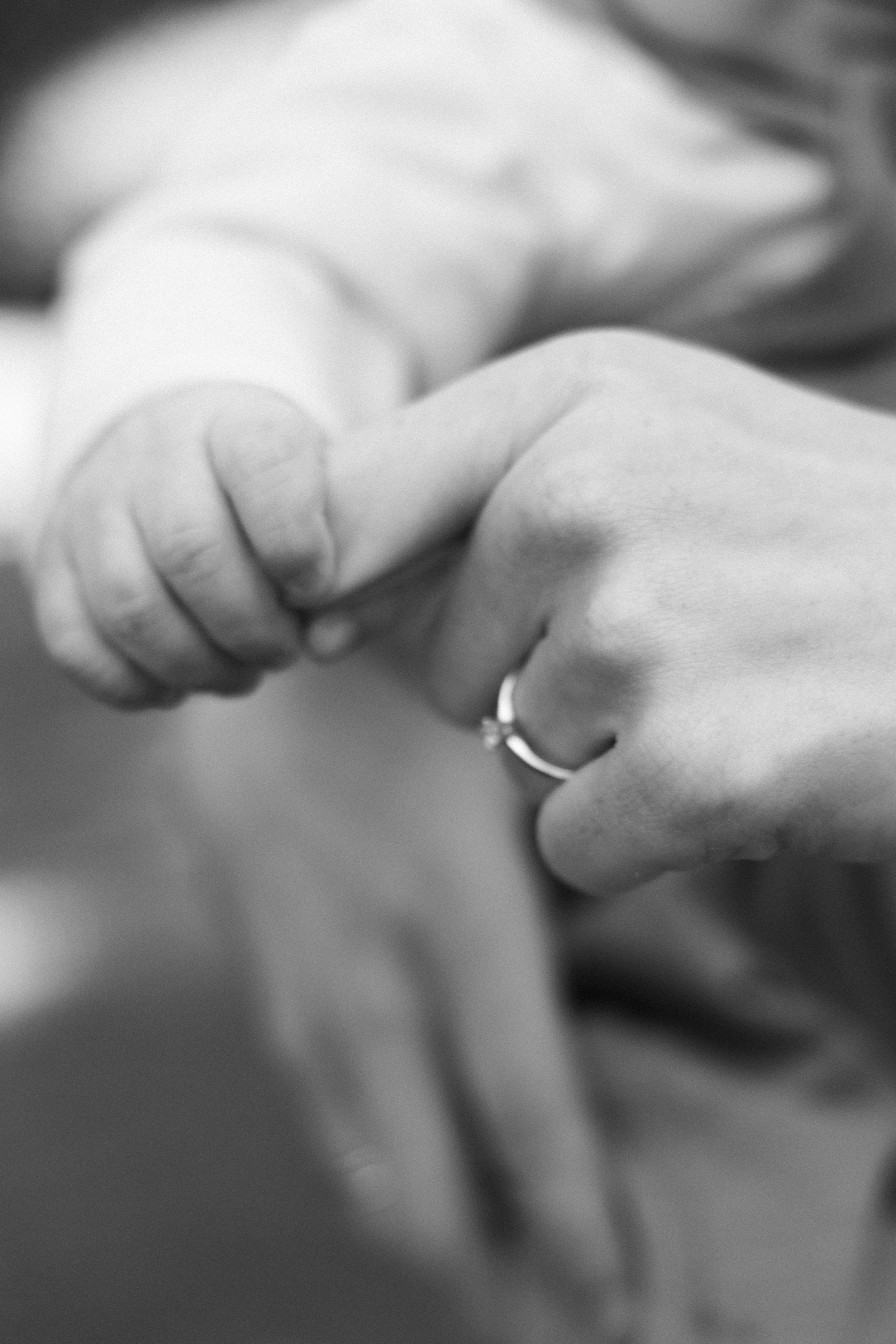 Nahaufnahme von einer Hand, die eine andere Hand hält, in Schwarz-Weiß.
