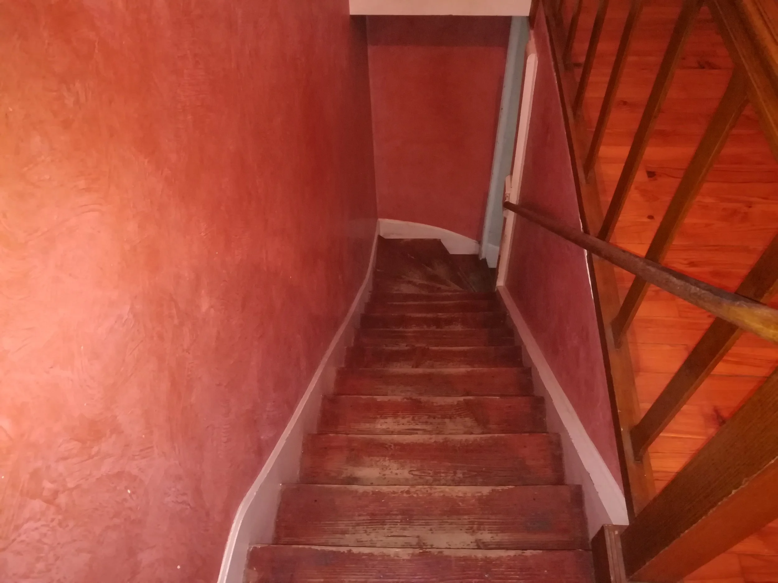 Escalier en bois avec un mur en bois derrière.