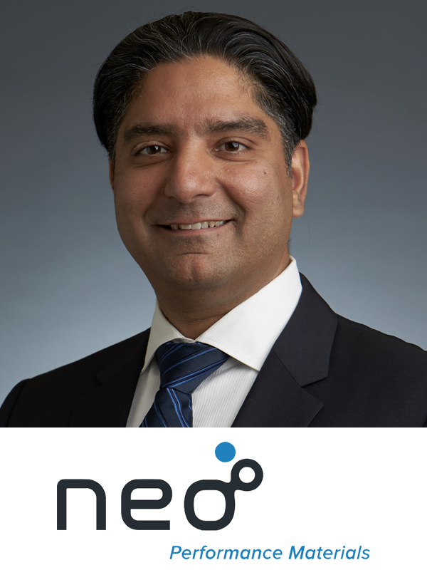 A professional headshot of a man in a black suit, white shirt, and blue striped tie, smiling with short dark hair, against a plain gray background. Below the image is the company logo 'neo' with the tagline 'Performance Materials.'
