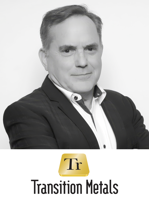 Black and white portrait of a middle-aged man in a suit with crossed arms, standing in front of a white background, with a logo reading 'Transition Metals' and a gold square with the letters 'Tr' underneath.
