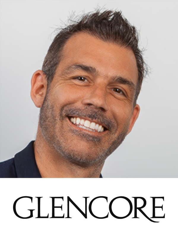A smiling man with short dark hair and facial hair, wearing a dark shirt, with the text 'GLENCORE' below him.