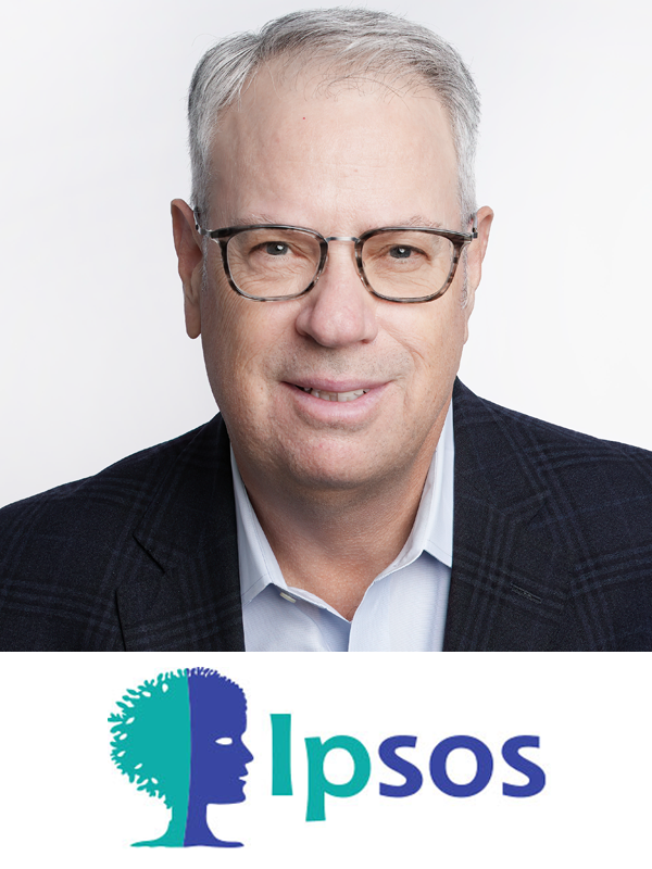 A middle-aged man wearing glasses and a dark blazer smiling, with an Ipsos logo featuring a profile of a face with hair resembling a tree on a white background.
