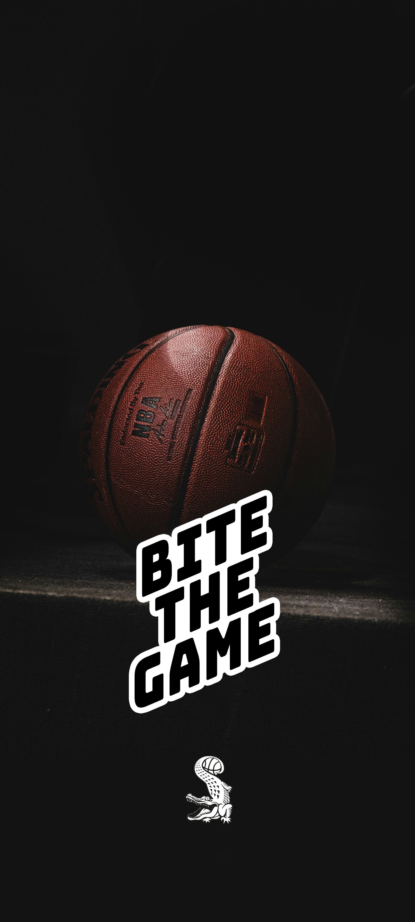 Pallone da basket su sfondo nero con la scritta "Bite the Game" e un logo di un coccodrillo con una palla sopra la testa.