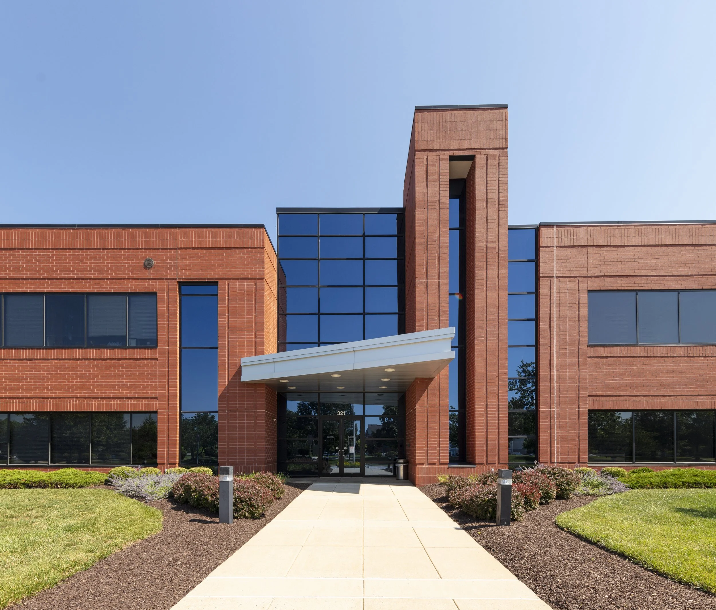 Main entrance of Ballenger Biotech Building in Frederick, Maryland, featuring the brick exterior and central glass entryway.