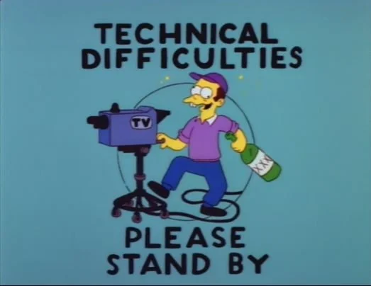 A cartoon character with glasses and purple hair, holding a TV camera and a bottle labeled 'X'. text above and below reads 'Technical Difficulties Please Stand By'.