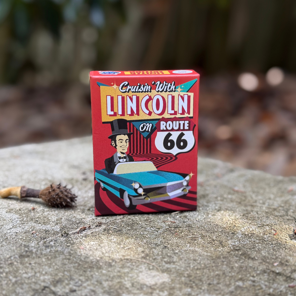 Cruisin' With Lincoln on Route 66 card game shown outside with dappled light. Created for the McLean County History Museum