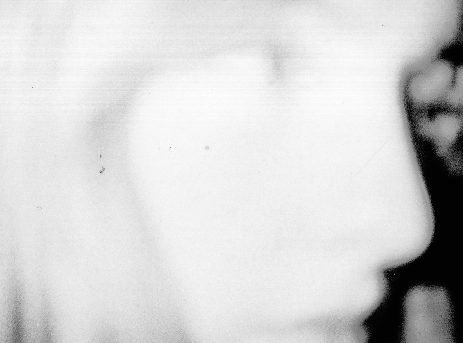 Close-up of Evie Rich's face in black and white, with part of an ear and cheek visible on the right side.