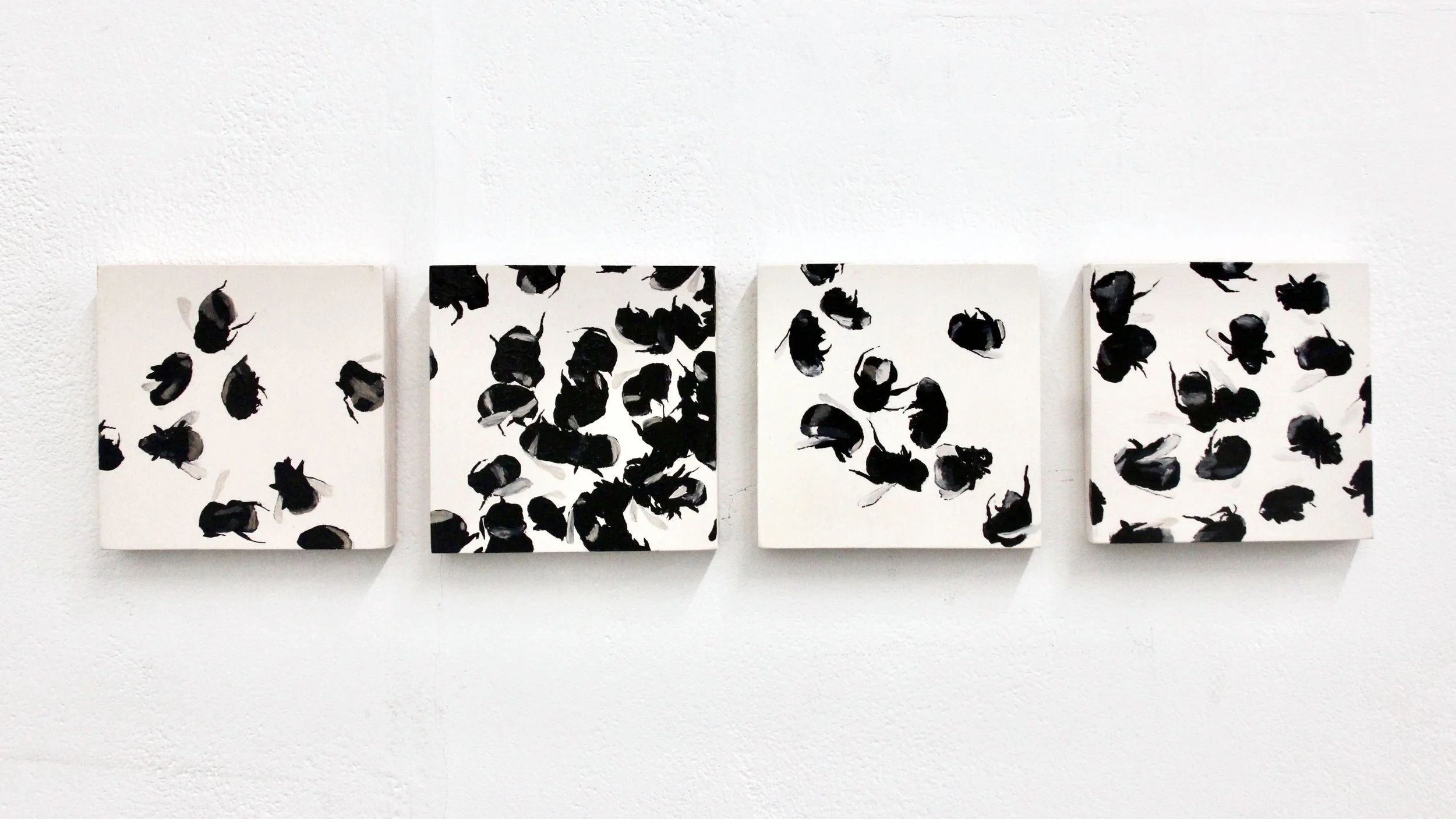 four paintings of bumblebees in swarms hanging on a white wall