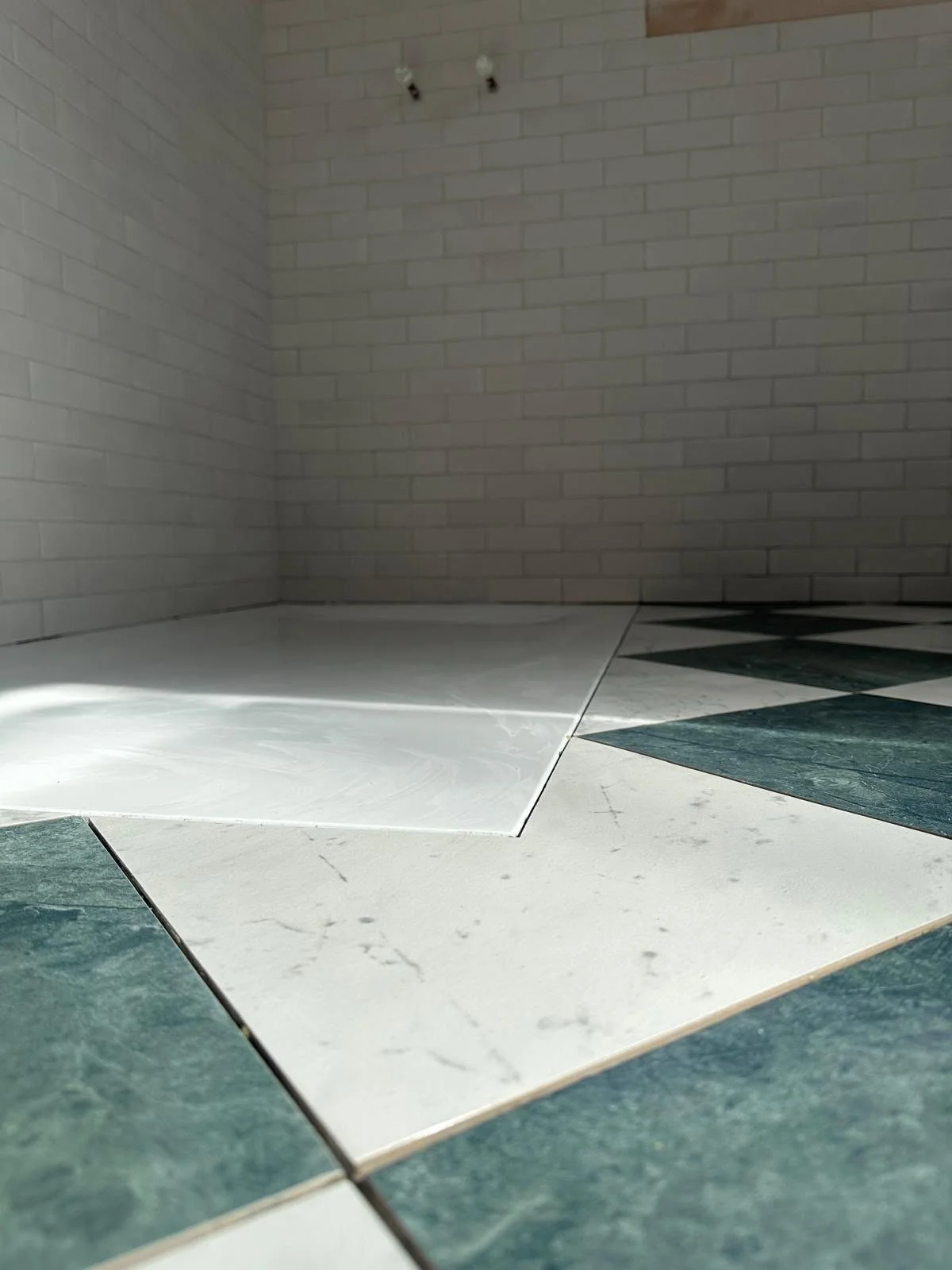 Close-up of a stone tile floor and a brick wall in a room or basement.