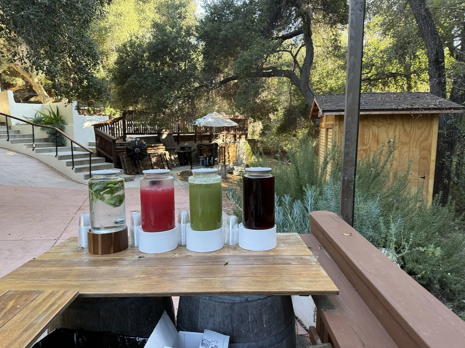Four colorful beverage dispensers at an outdoor Minkxology event