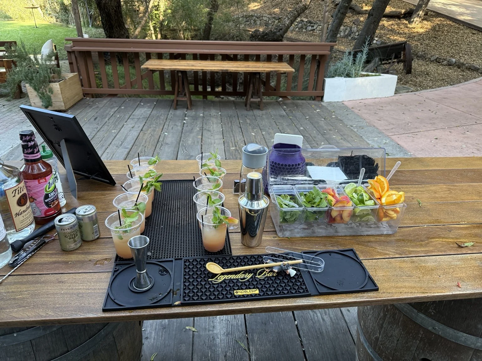 Fresh garnishes and peach cocktails arranged at an outdoor bar