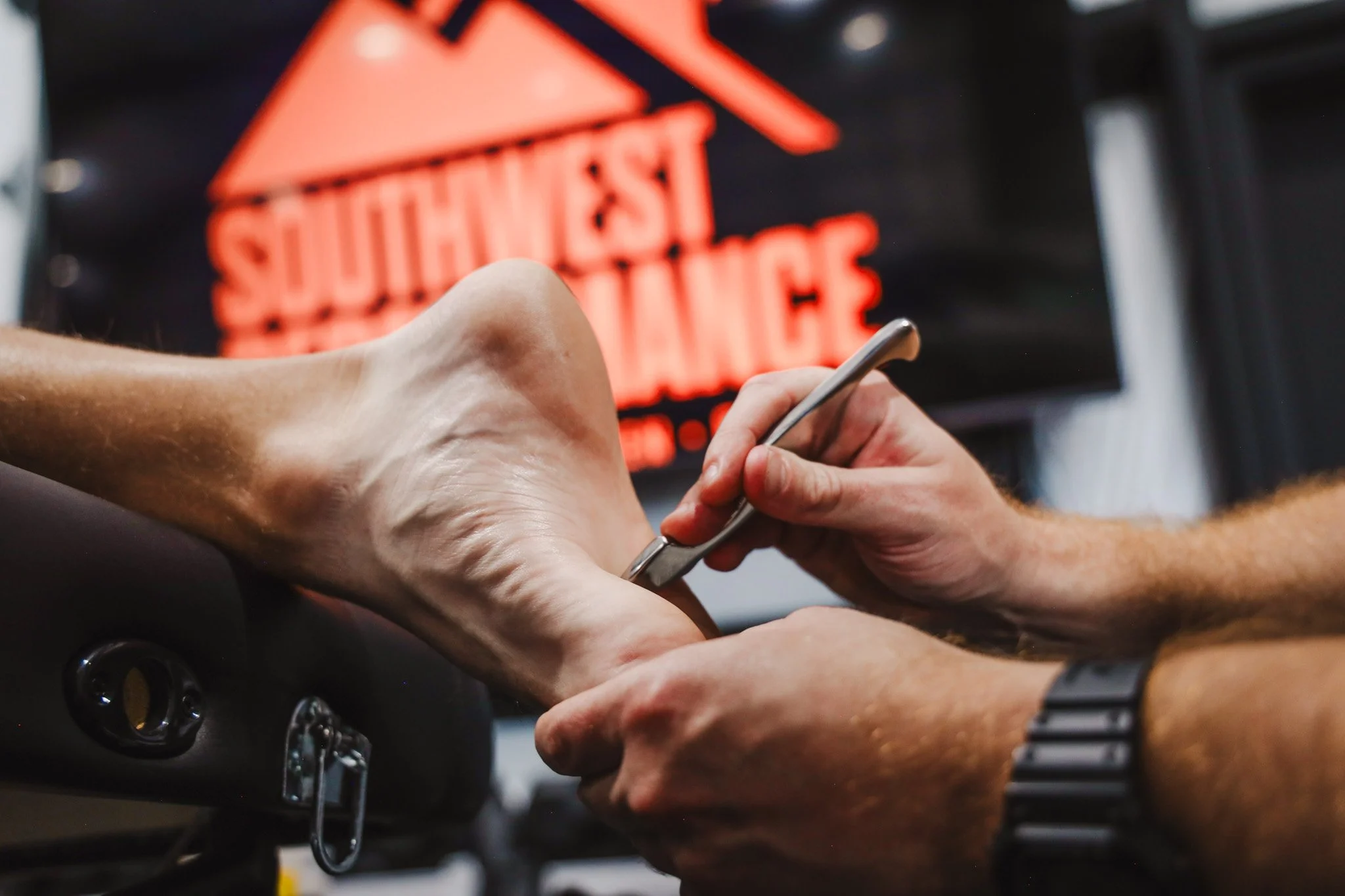 Close-up of a person receiving a vaccine injection in their arm in a clinical setting with a warning sign that reads 'Caution: Suspected' in the background.