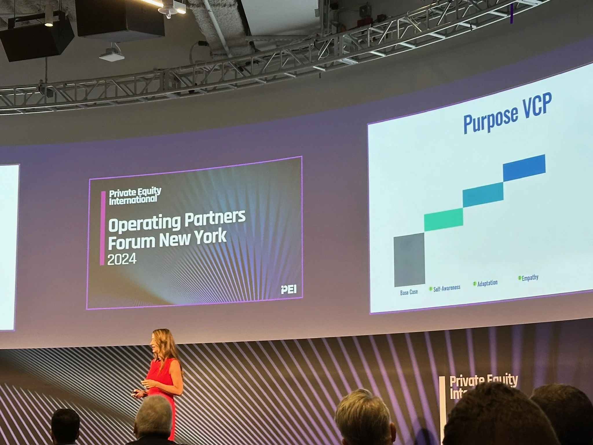 Tracey Abbott presenting the Purpose Value Creation Plan on stage to a live audience.