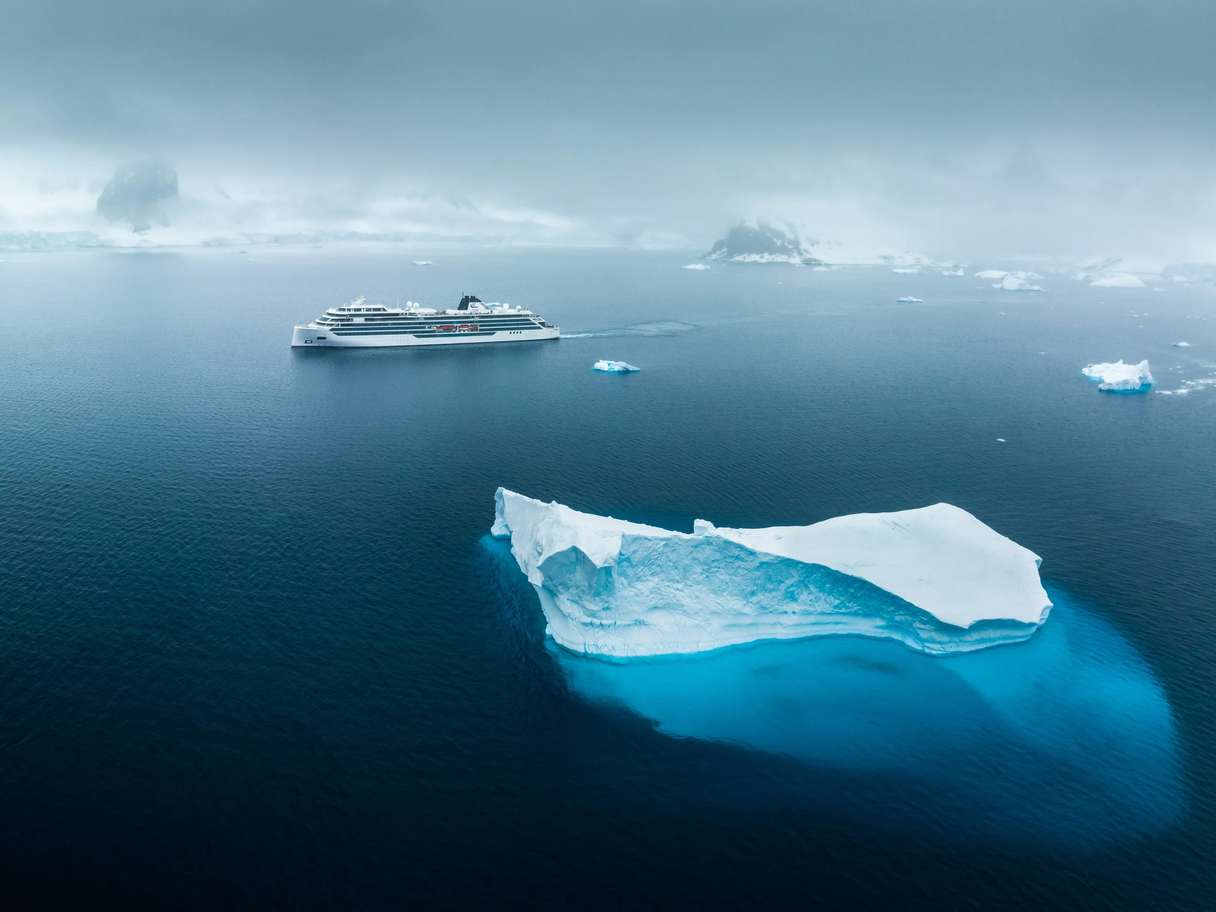 Luxury cruise ship sailing through Arctic waters, showcasing the adventure and unique destinations available through Travel with Lori B.