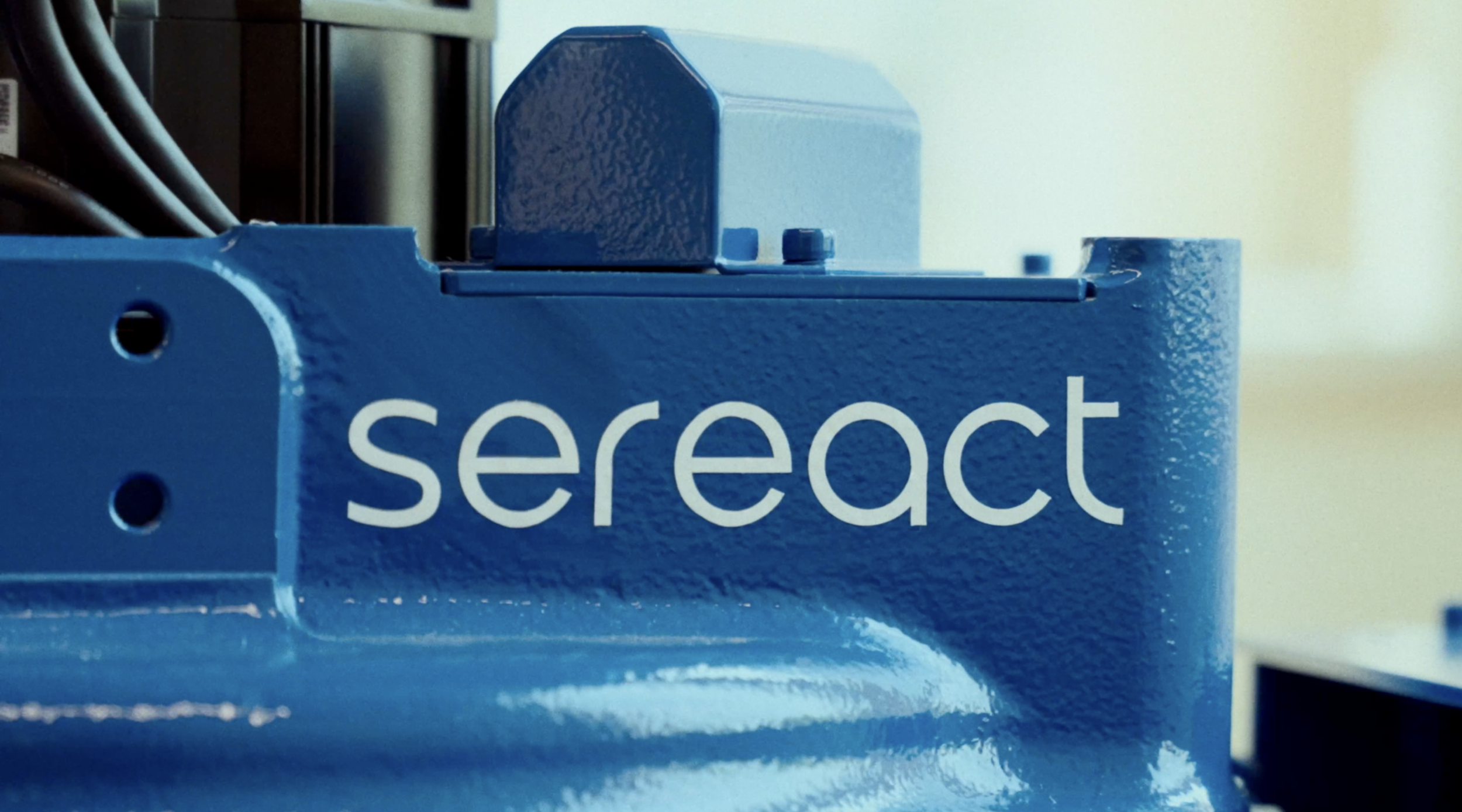 Close-up of a blue metal box with the word "select" printed on it, connected to wires and electronic components.