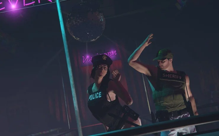 Two people dressed as police and sheriff officers on a stage or dance floor with neon lights.