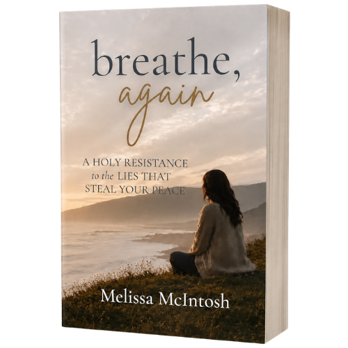 Book titled "breathe again" by Melissa McIntosh, featuring a woman sitting on a hill near the ocean at sunset