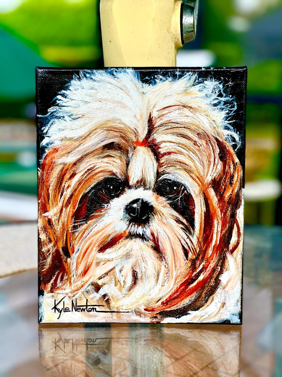 Colorful pet portrait of a small long-haired dog with dark eyes and nose, signed by Kyle Newton.