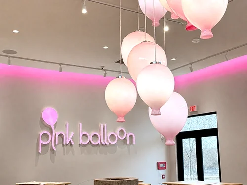 Pink Balloon Neptune retail entrance with a sculptural balloon chandelier.
