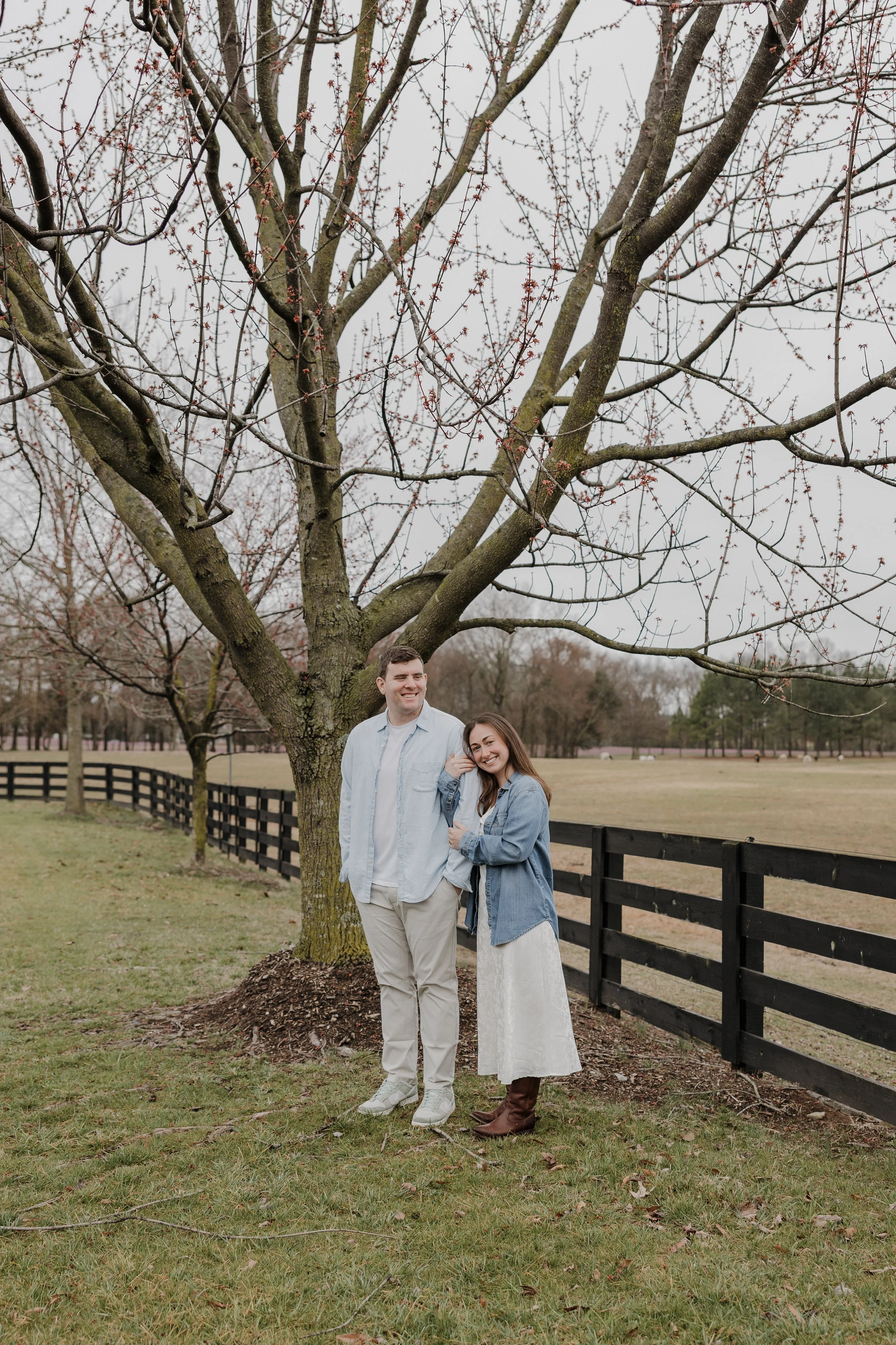 Couple embracing beneath the trees at Morning Glory Farm in Charlotte, NC
