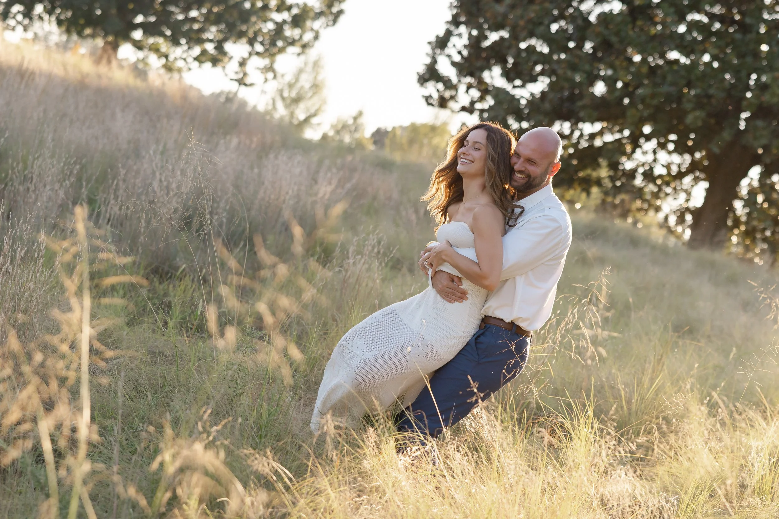 Candid engagement photo of Keely and Grant sharing a quiet moment together at NCMA Park