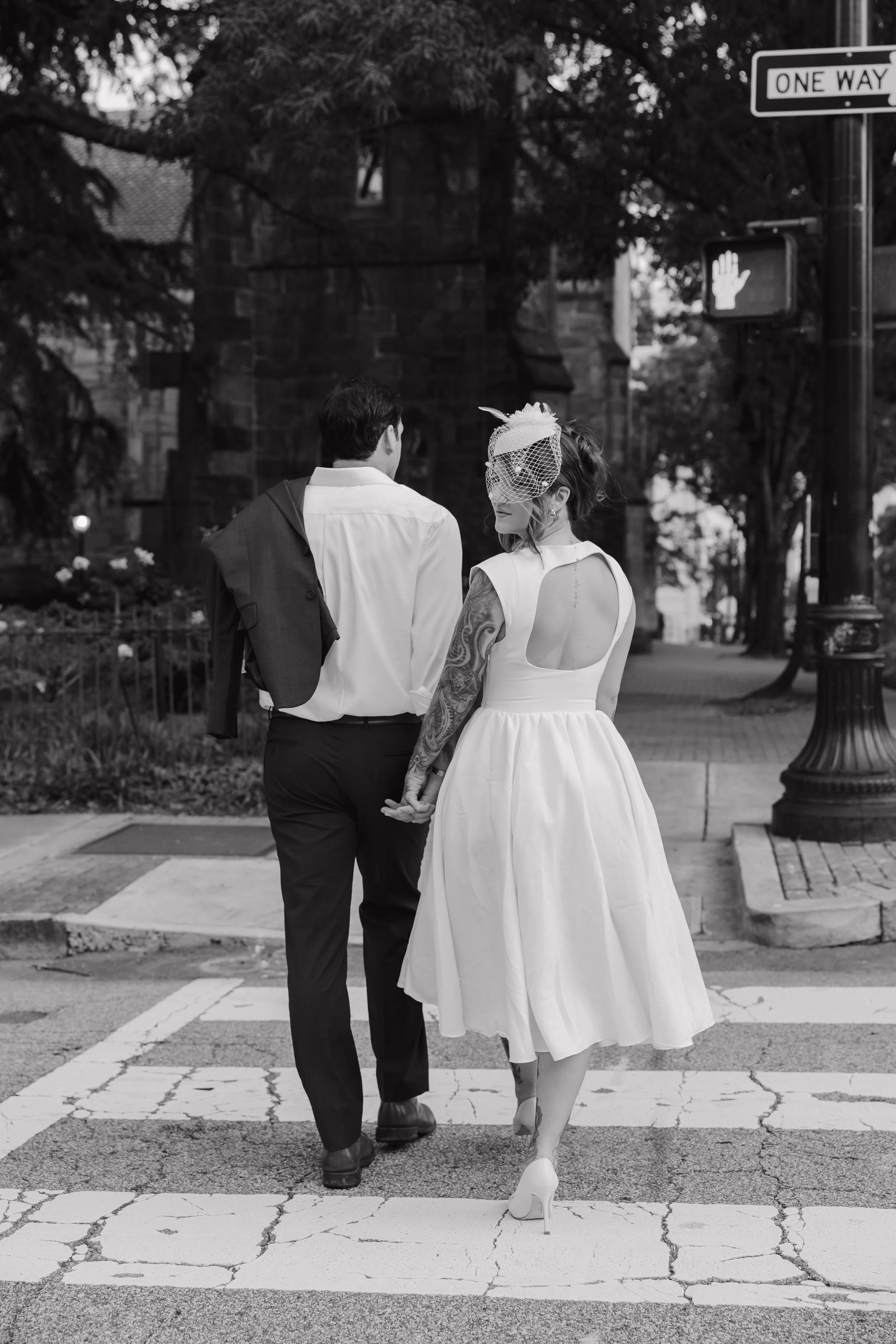 Engaged couple walking through historic downtown Raleigh holding hands