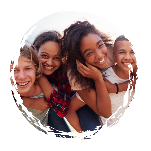 Four friends smiling and close together, looking at the camera, with a white background and a torn paper circle effect.